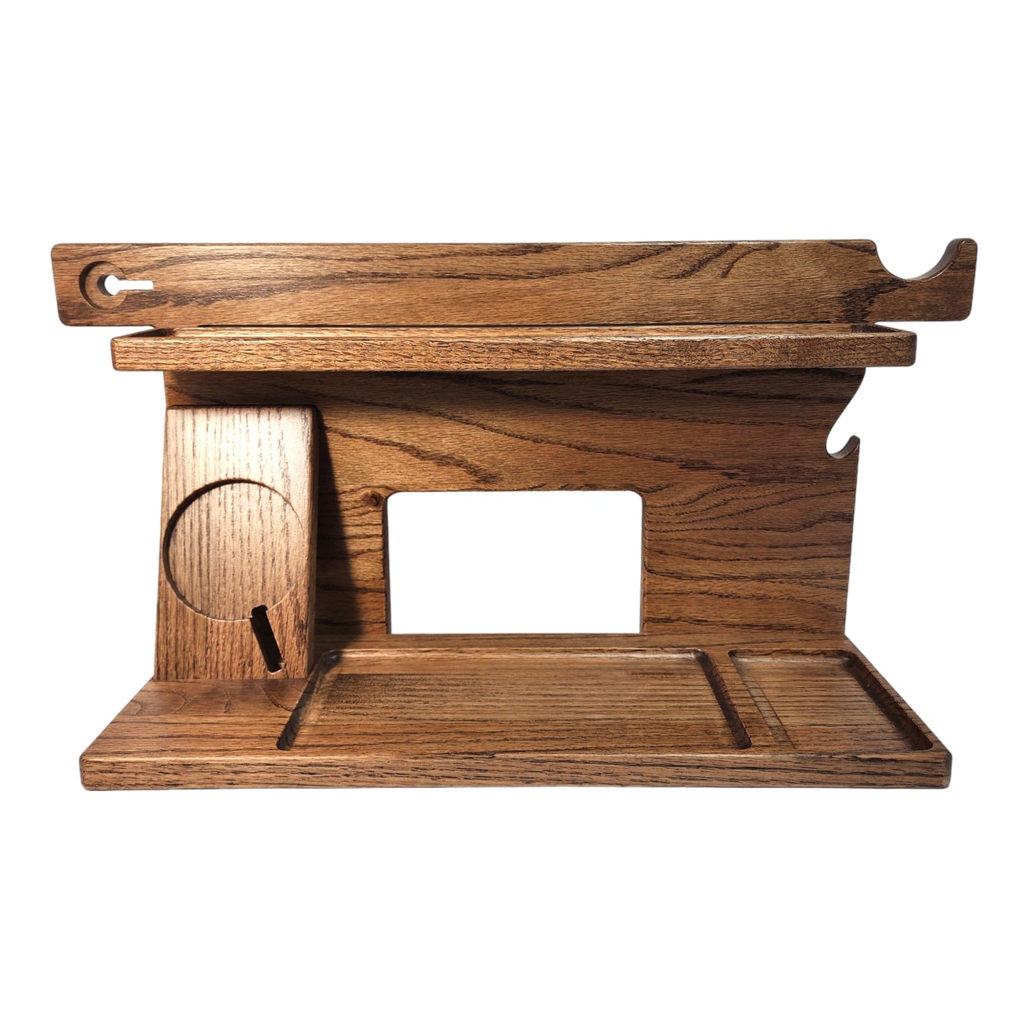 An empty CPAP Smart Stand made by Custom Cave Works. The stand is on a white background and includes places to put your smartphone, smartwatch, change, keys and wallet. The stand is sold oak wood that has a dark satin finish.