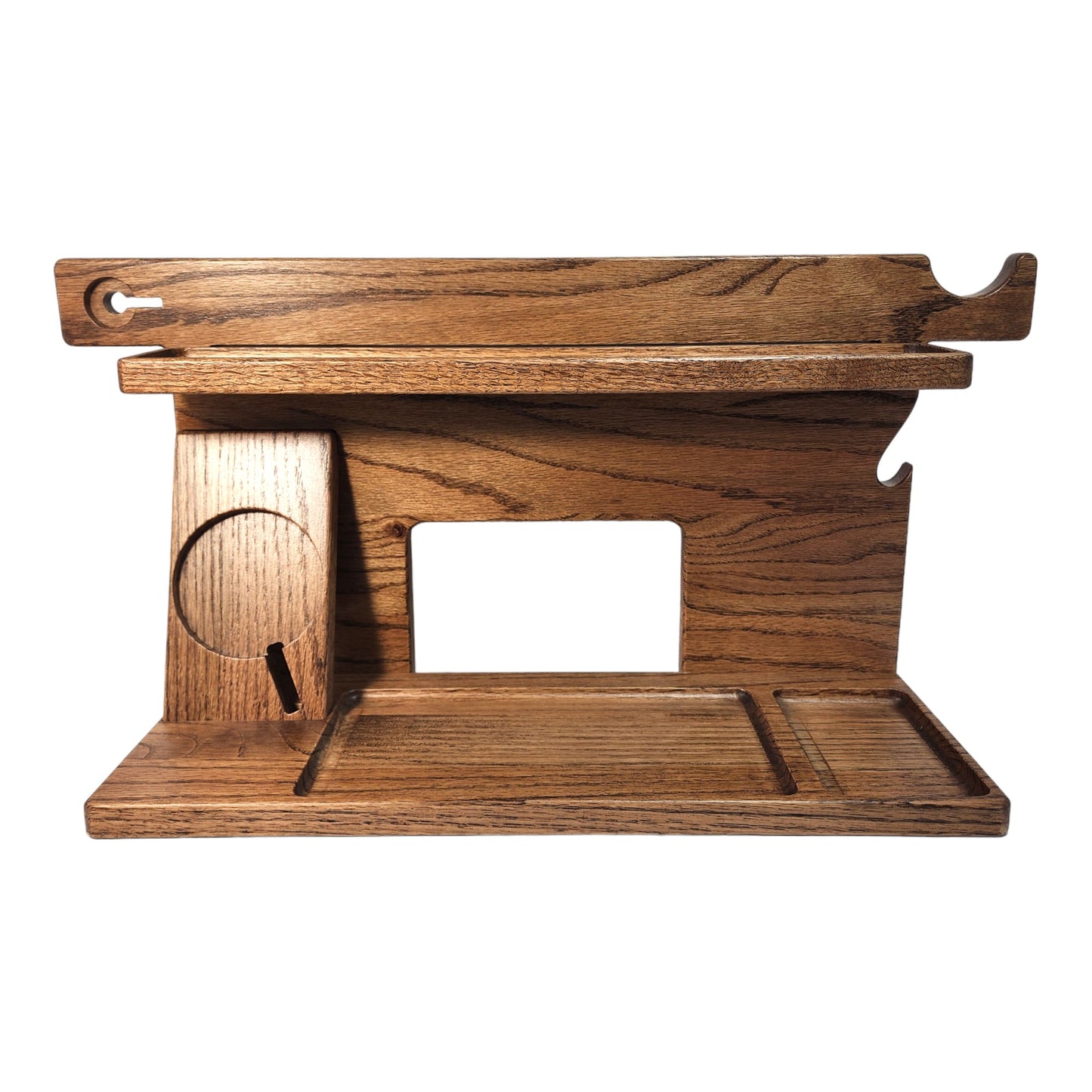 An empty CPAP Smart Stand made by Custom Cave Works. This smart stand does not include the optional wireless phone charger. The stand is on a white background and includes places to put your smartphone, smartwatch, change, keys and wallet. The stand is sold oak wood that has a satin finish.