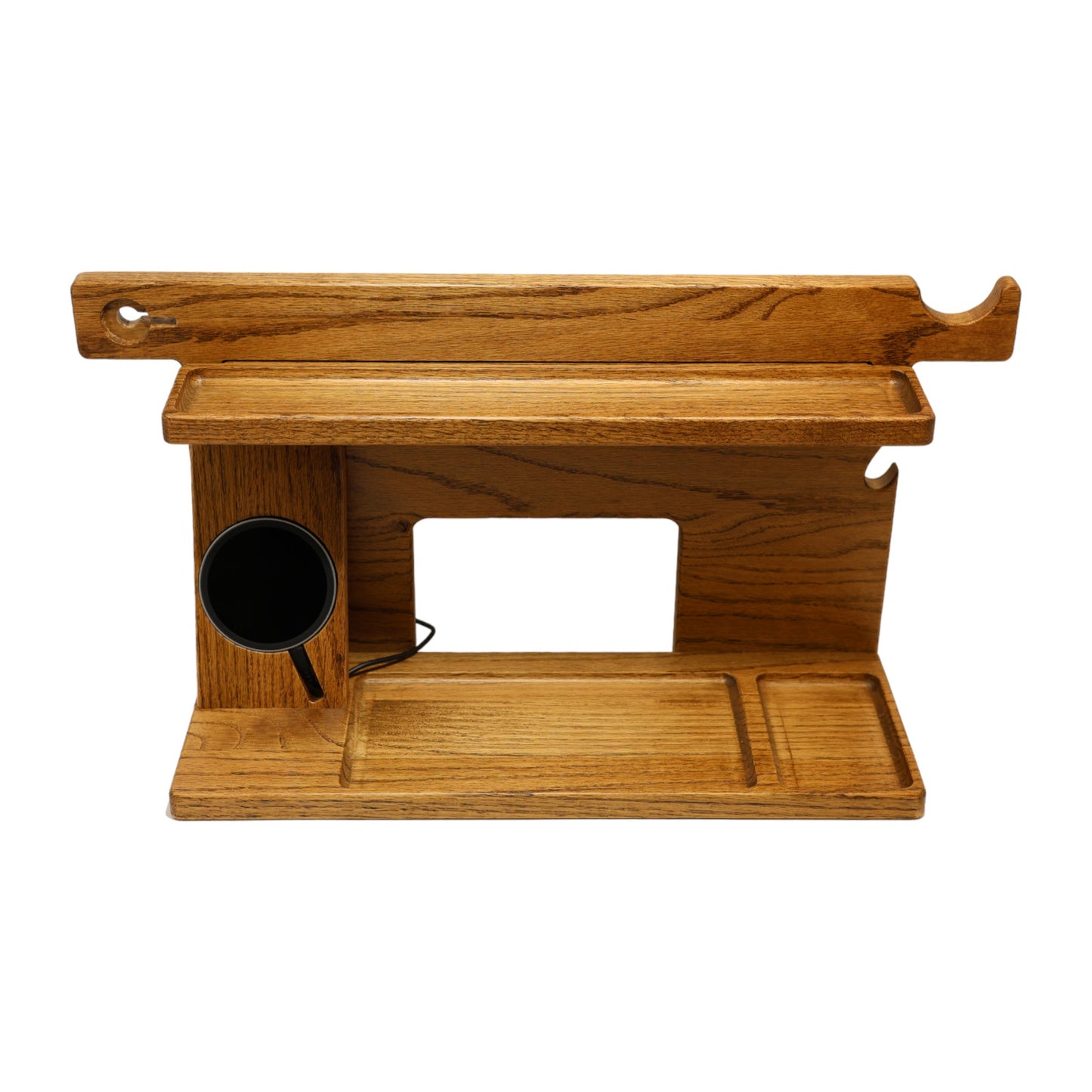 An empty CPAP Smart Stand made by Custom Cave Works. This smart stand includes a wireless phone charger. The stand is on a white background and includes places to put your smartphone, smartwatch, change, keys and wallet. The stand is sold oak wood that has a satin finish.