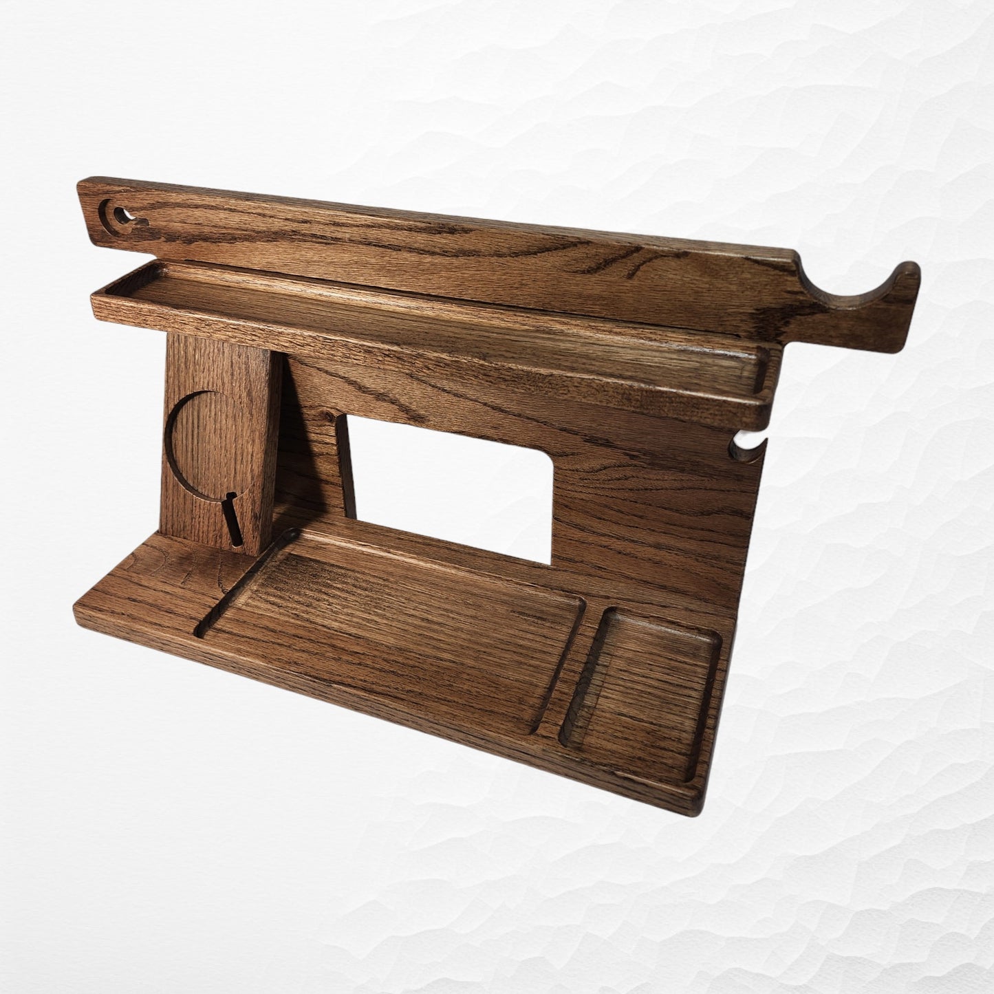 An empty CPAP Smart Stand made by Custom Cave Works.  This smart stand does not include the optional wireless phone charger.  The stand is on a white background and includes places to put your smartphone, smartwatch, change, keys and wallet.  The stand is sold oak wood that has a satin finish.  